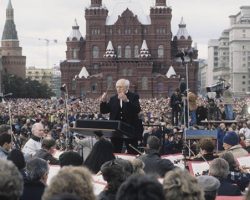 Rostropovich, NSO and Choral Arts Make History in Moscow Blue Heart takes the Choral Arts Society of Washington on tour to Russia with the National Symphony Orchestra, conducted by Mstislav Rostropovich, the cellist who had defected back in 1974. Just days before departure, Russia finds itself in the throes of a constitutional crisis, involving deadly protests and the barricading of its Parliament building. Undaunted, choir, orchestra and maestro “Slava” press forward, coming together for a landmark concert in Moscow—the first time anything other than a military parade had occurred on Red Square. In front of an audience of some 100,000, including President Boris Yeltsin, Russia is opened to the Western world, with millions more worldwide watching and listening to the historic live broadcast.